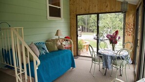Una habitación acogedora con una cama, una mesita con sillas, una ventana y vistas al exterior.