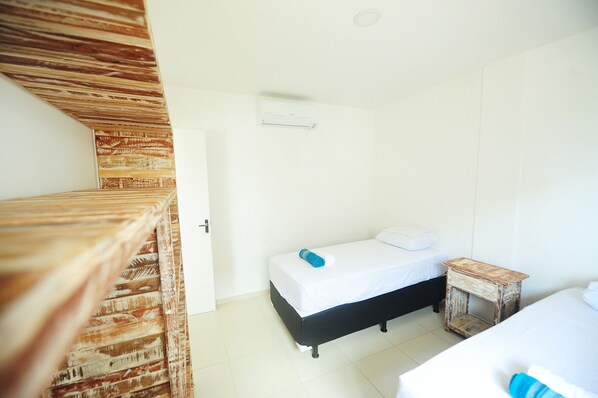 Un dormitorio con una cama, una mesita de noche y una pared de madera.