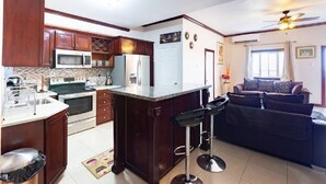 Una cocina moderna con armarios de madera oscura, una isla central y un taburete de bar.