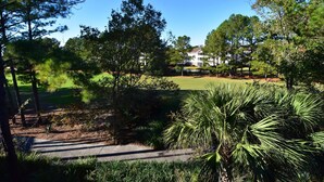 A golf course with a pathway leading to a clubhouse. - Cypress Bend Apartment 532 (North Myrtle Beach)