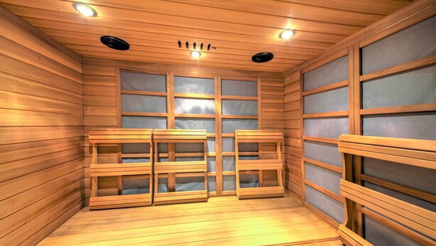Un sauna avec des bancs en bois et des fenêtres en verre dépoli.