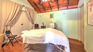 Une chambre à coucher avec un lit, une chaise, un bureau et un ventilateur de plafond.