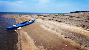 Um caiaque numa praia arenosa sob um céu claro.