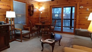 A cozy cabin interior with a wooden interior, a dining area, and a balcony with a view. - Lakefront Log Home w/ Dock Slip, 30% Weekly Discount, 2 Miles from Nat. Park (Swanton)