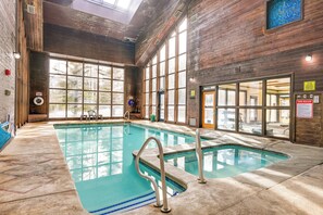 An indoor swimming pool with clear glass walls, wooden beams, and a tiled floor. - Brian Head Condo w/ Pool Access - Steps to Resort! (Brian Head)
