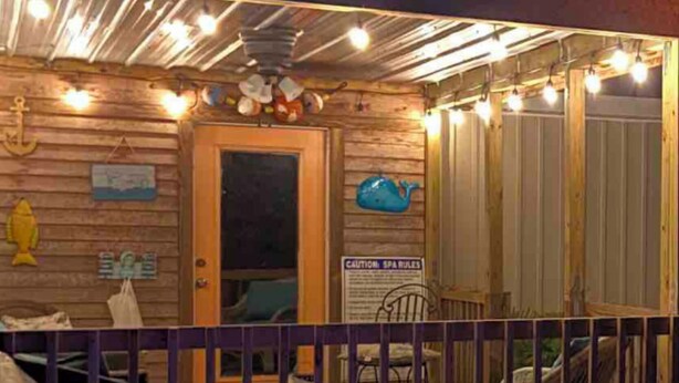 Un jacuzzi con terraza de madera y un letrero que indica las normas del spa.