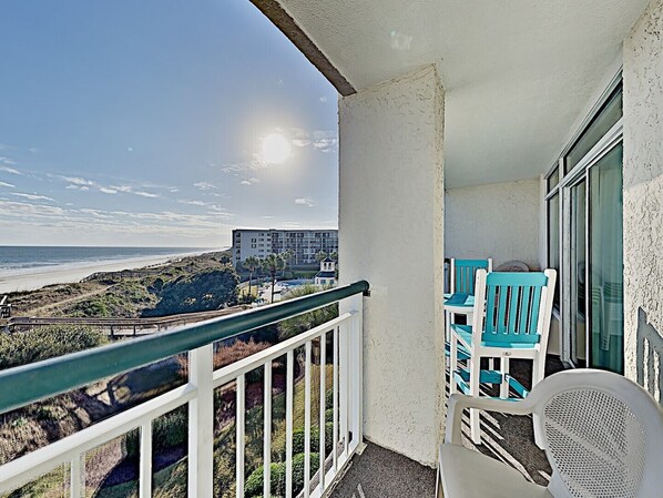A balcony with a view of the beach and a building in the background. - Bridgewater 301 - End Unit, Lazy River, Pool (Pawleys Island)