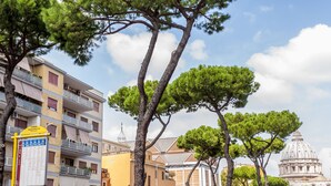 A building with balconies and a large dome in the background. - THE MUSE your home facing St. Peter’s Dome  (Roma)