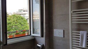 A bathroom with a window, a towel rack, and a wall-mounted thermostat. - THE MUSE your home facing St. Peter’s Dome  (Roma)