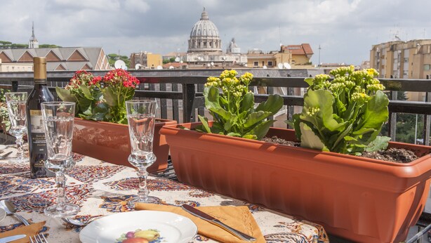 A table set for dining with a view of a historic building in the background. - THE MUSE your home facing St. Peter’s Dome  (Roma)
