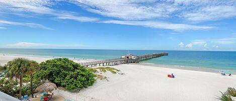 Na praia, espreguiçadeiras, guarda-sóis, toalhas de praia