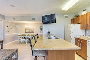 Enjoy meals in this well-equipped kitchen with a central island, oven, and flat-screen TV.