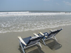 Ranta lähistöllä, aurinkotuoleja, rantapyyhkeitä