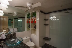 A modern bathroom with a glass sink, white toilet, and a shower with frosted glass doors. - Playa Bonita Casa de los Abuelos located on Los Muertos Beach 2BD Condo for rent (Puerto Vallarta)