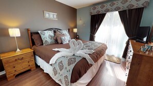 A neatly arranged hotel room with a bed, bedside tables, a dresser, and a television.
