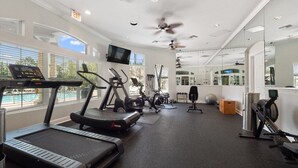 A gym with treadmills, exercise bikes, and free weights.