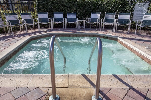 A swimming pool with a metal ladder, surrounded by lounge chairs and a sign indicating 'Emerald Island'.