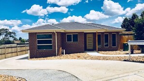 A single-story brick house with a gabled roof, a front entrance, and a small porch area. - Bacchus Marsh Villa unit 1 (Darley)