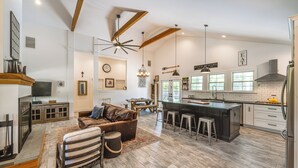 A spacious kitchen with a large island, wooden beams, and a modern chandelier. - Distinctive Hamptons Home w/ Pool Near Bay, Ocean (Hampton Bays)