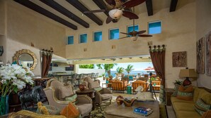 A spacious living area with a view of the ocean, furnished with sofas, chairs, and a coffee table. - 2 FREE NIGHTS IN CABO at Casa Alcini! (Cabo San Lucas)