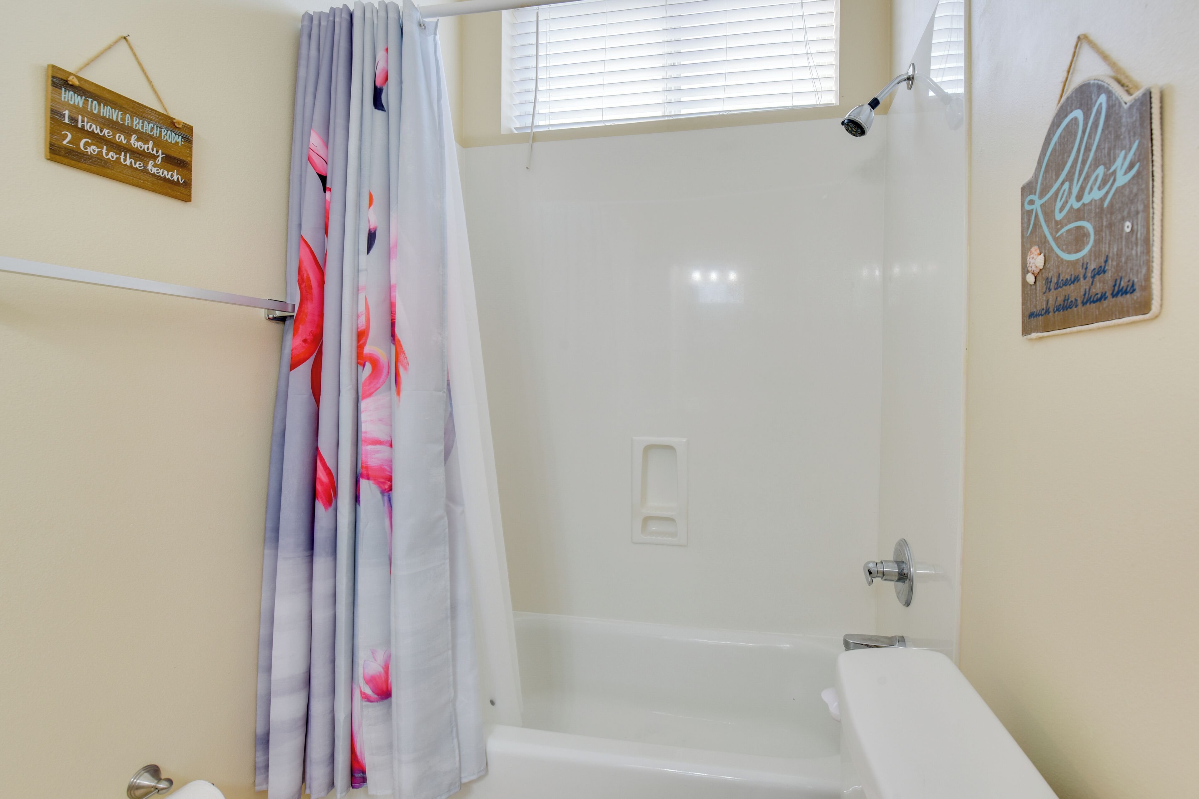Ein Badezimmer mit Dusche, Toilette und Badewanne. An der Wand befinden sich zwei Schilder, eines mit einer Schritt-für-Schritt-Anleitung und das andere mit dem Wort 'Relax'.