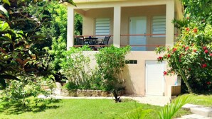 Un immeuble de deux étages doté d’un balcon et d’un garage.