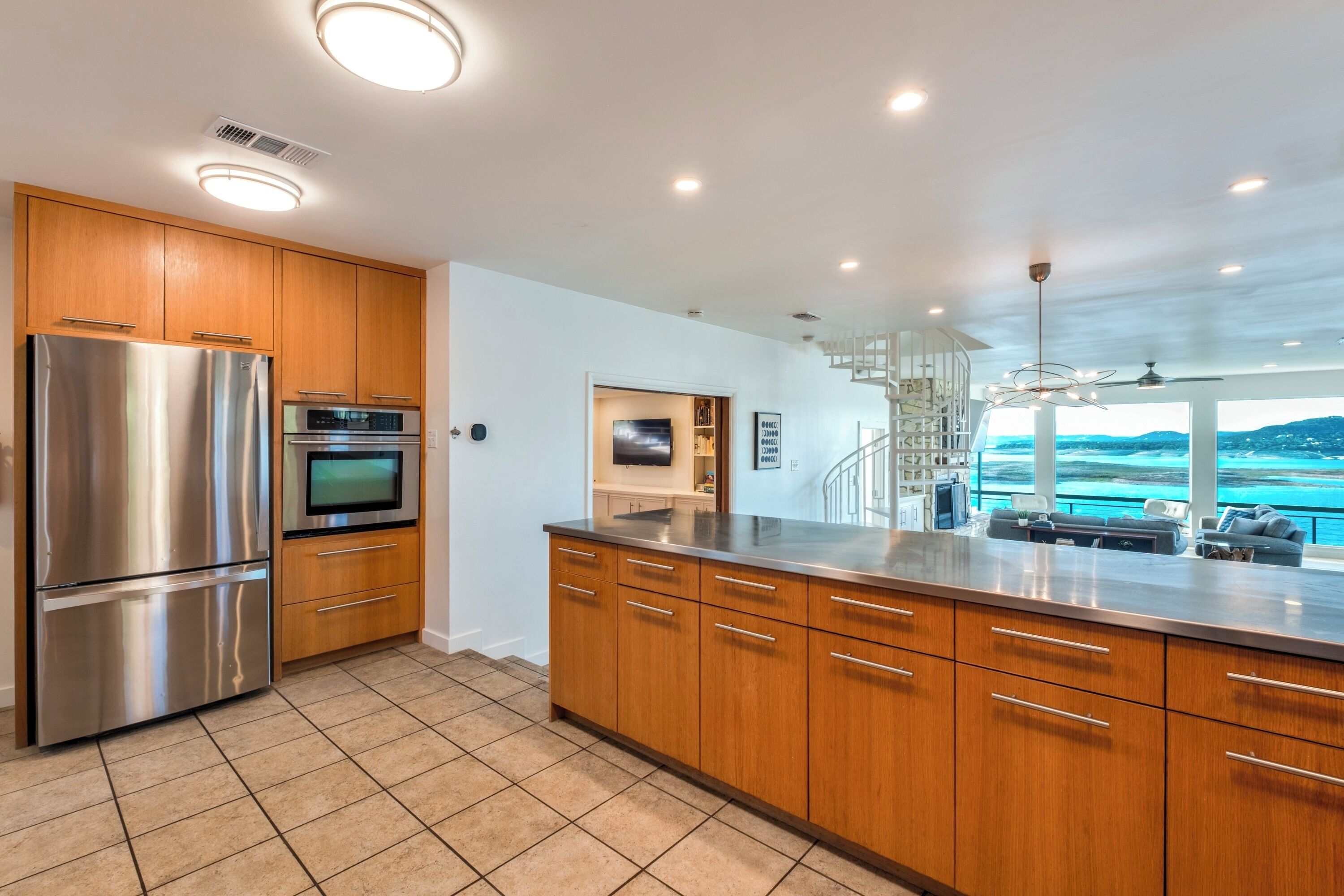 A modern kitchen with stainless steel appliances, wooden cabinets, and a large island.