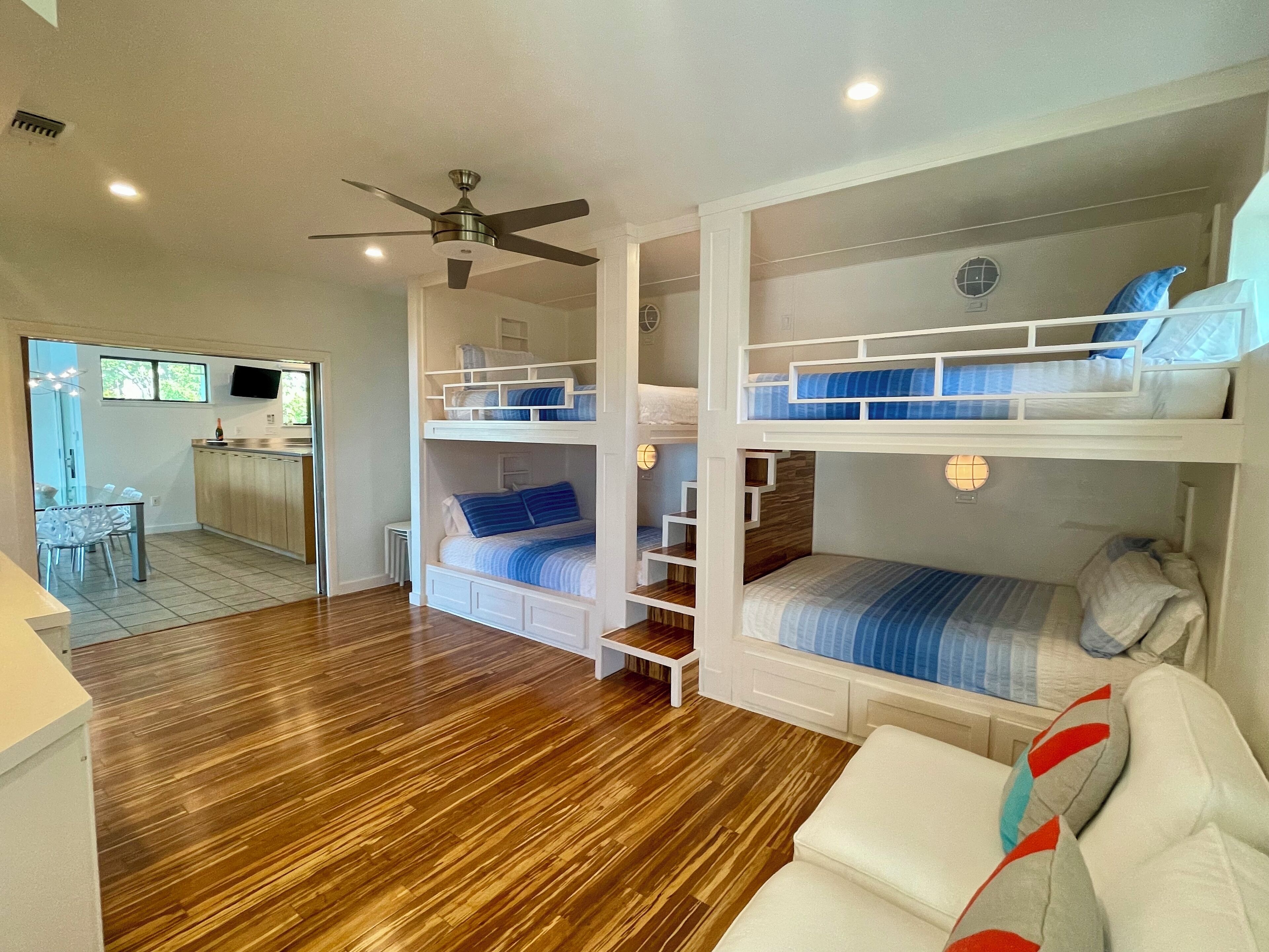 A compact studio apartment with a kitchenette, a dining area, and a living space with bunk beds.