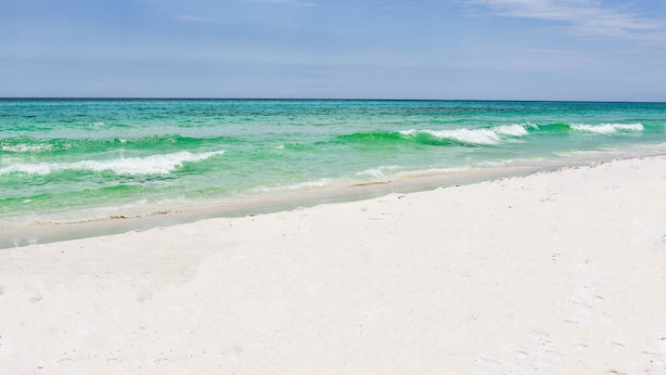 Una playa con agua turquesa cristalina y arena blanca.