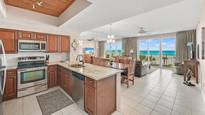 A spacious kitchen with a central island, wooden cabinets, and a large window overlooking the ocean. - BOB AND MARY'S BEACH RETREAT,  FABULOUS GULF VIEWS, GREAT 5  STAR REVIEWS.. (Destin)