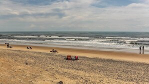 Ein Strand mit Sandküste und dem Meer im Hintergrund.