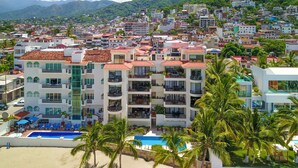 A hotel with multiple floors, balconies, and a swimming pool.