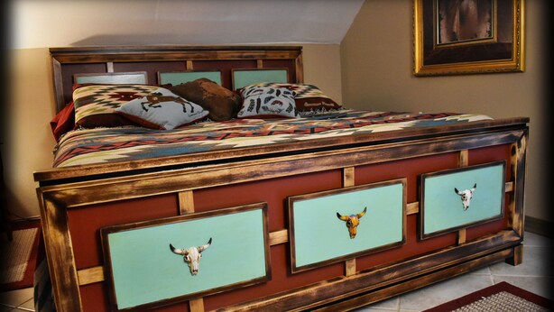 Een bed met een houten hoofdbord, meerdere kussens en een sprei.