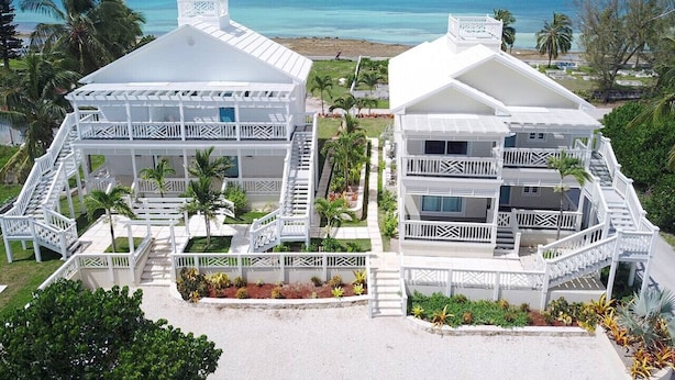 A beachfront hotel with multiple balconies, a pool area, and a view of the ocean. - Bayfront 1BR Apt - Central Location & GREAT Rates! (Governor`s Harbour)