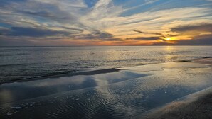 A beach with a sunset, calm water, and a clear sky. - Inn at Dauphin Island 310 Beautiful Unit with Wonderful Views!! (Dauphin Island)