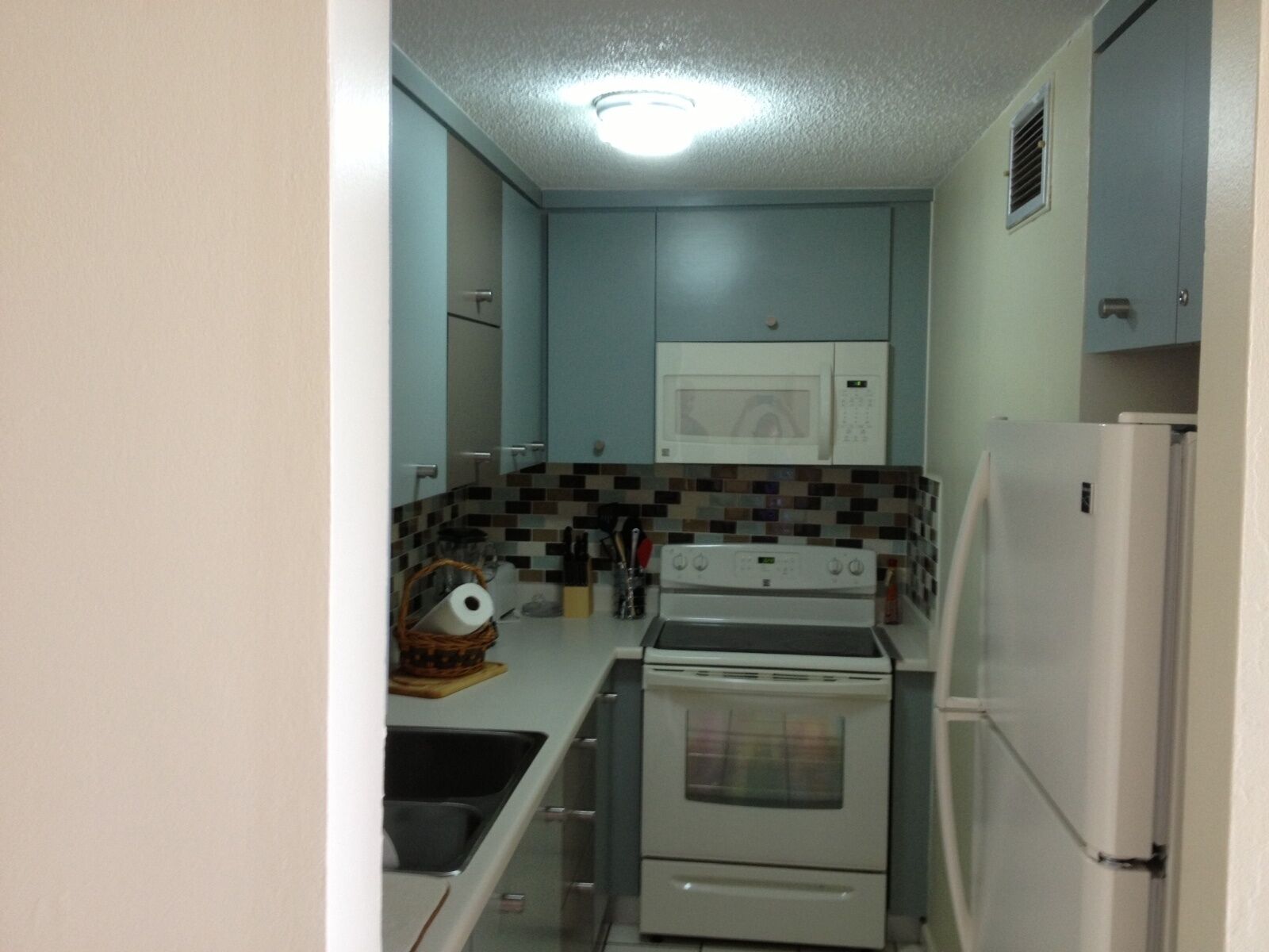 A compact kitchen with a microwave, stove, and refrigerator.