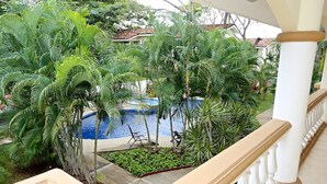 Una piscina circondata da vegetazione lussureggiante, con un edificio sullo sfondo.