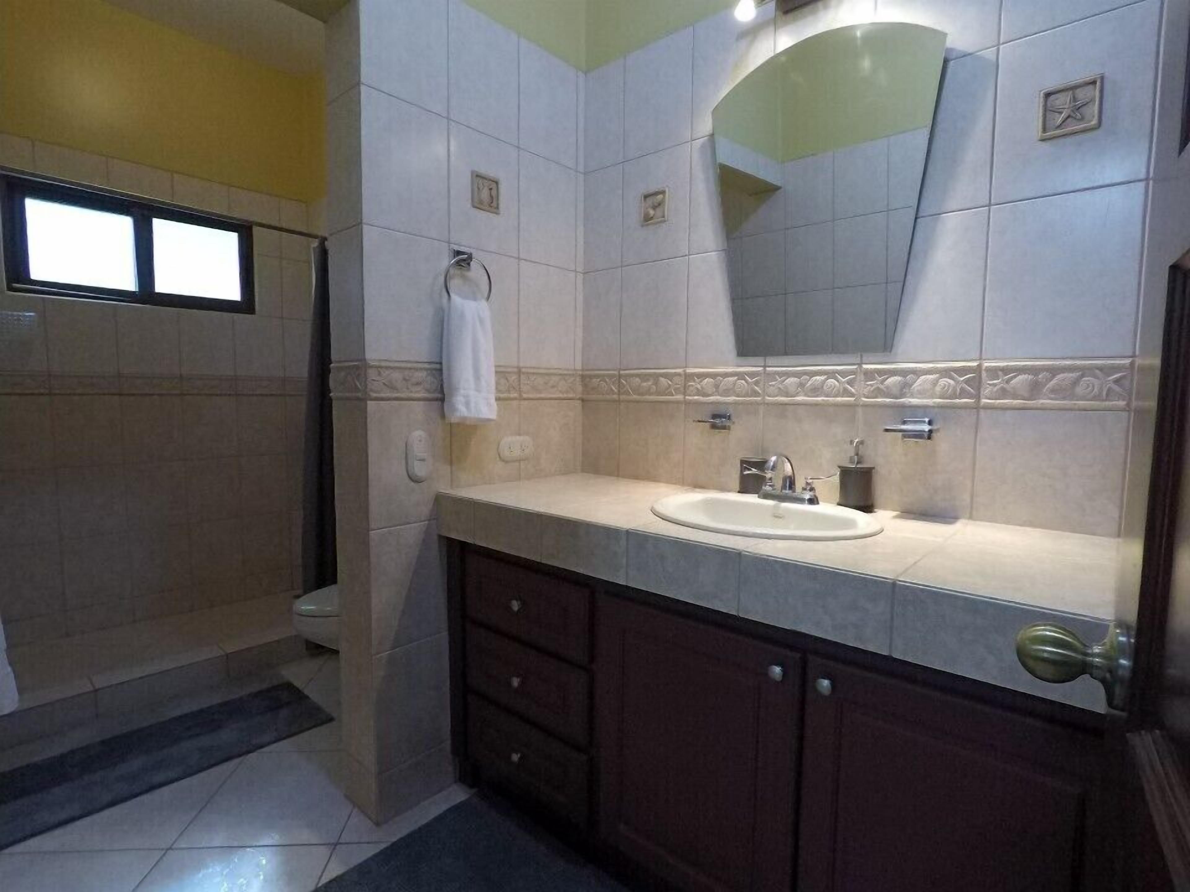 A bathroom with a sink, mirror, and a towel rack.