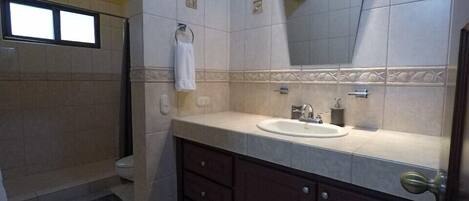 A bathroom with a sink, mirror, and a towel rack.