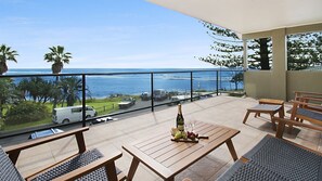 Enjoy ocean views from this balcony with a glass railing, perfect for sipping champagne and snacking on fresh fruit.