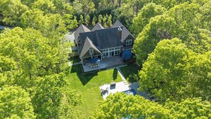 An aerial view of a house surrounded by lush green trees. - Wainscott Southampton Estate Timeless luxury with a private pool,... (Wainscott)