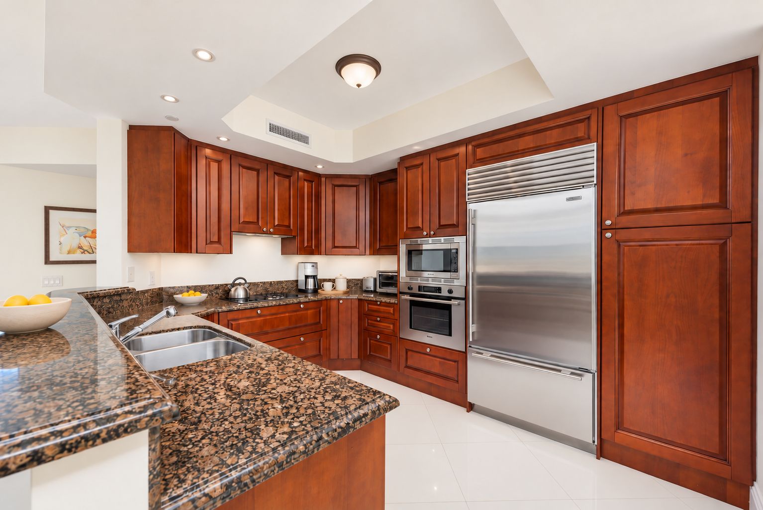 A modern kitchen with granite countertops, stainless steel appliances, and wooden cabinetry.