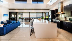 Una cocina moderna con una isla central, electrodomésticos de acero inoxidable y un amplio ventanal con vistas panorámicas.