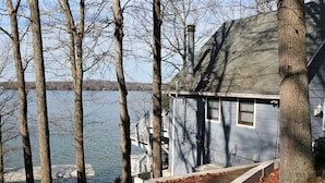 Una casa con un muelle que se adentra en un lago, rodeada de árboles.