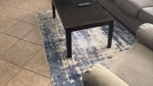 Una sala de estar con sofá, una mesa de centro y un área de cocina al fondo.