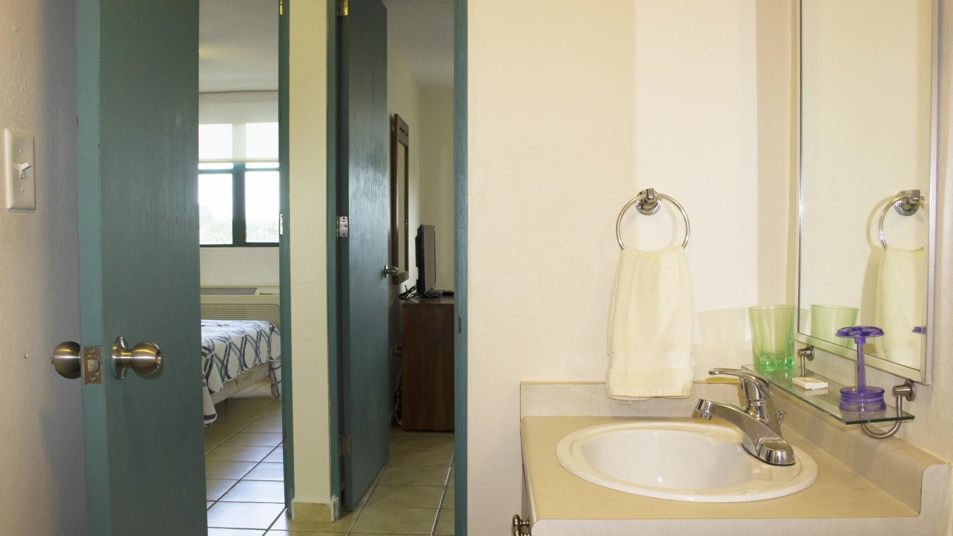 Une salle de bain équipée d’un lavabo, d’un miroir et d’un porte-serviettes.