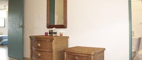 Une salle de bain avec un meuble-lavabo en osier, un miroir et des toilettes.