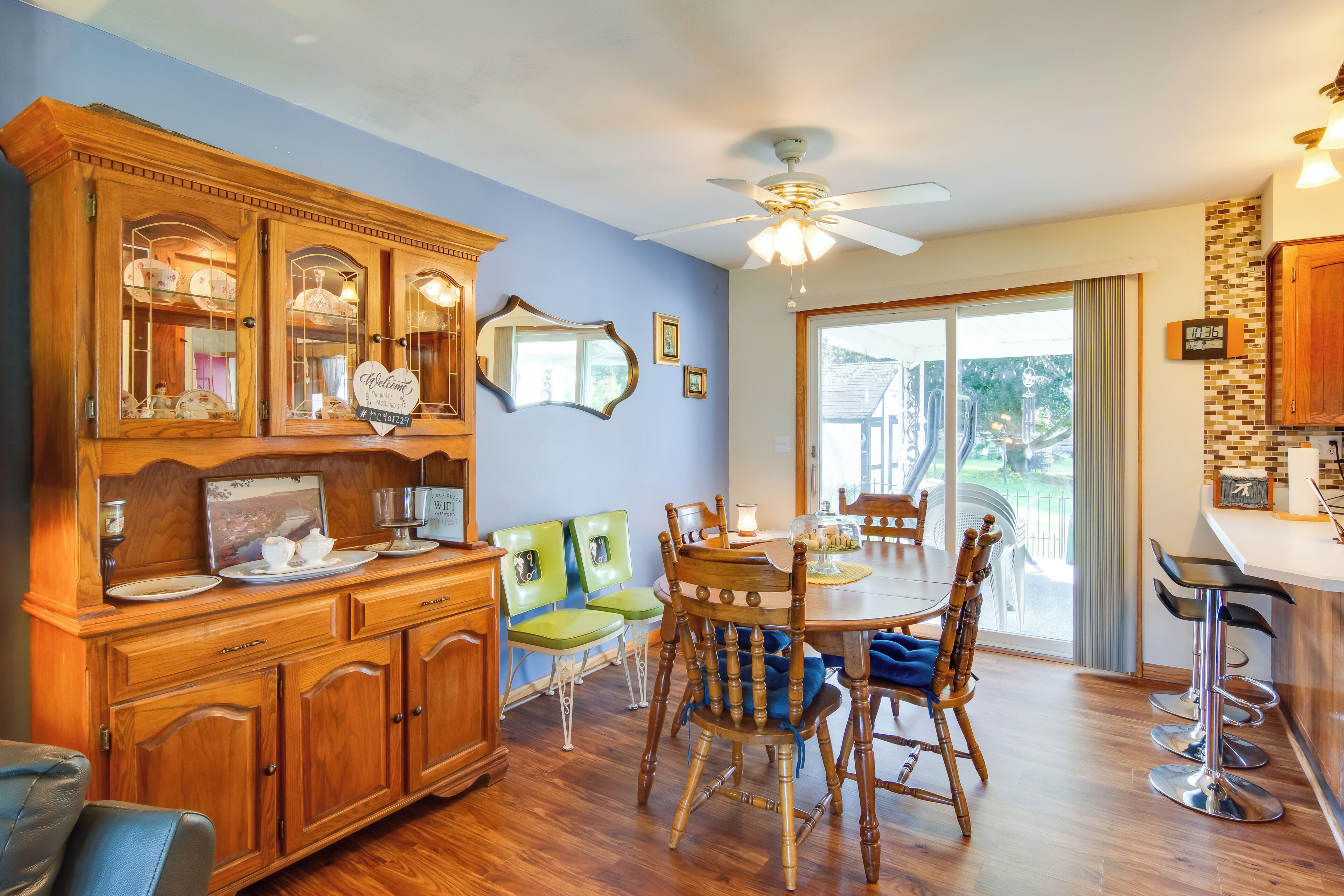 Comedor con muebles de madera, ventilador de techo y vista al exterior.