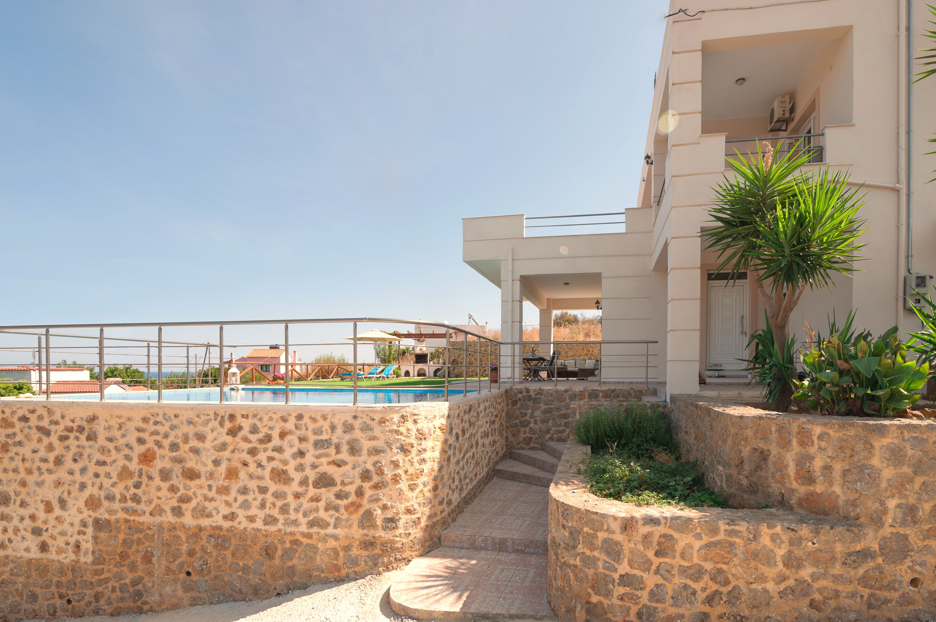 Uma área de piscina com pedras e escadas que levam a um edifício com varanda.