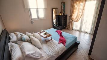 A bedroom with a bed, a dresser, a mirror, and a window with curtains.